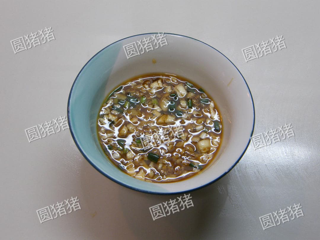 An uncooked soy-vinegar sauce with chopped aromatics in a small white bowl.