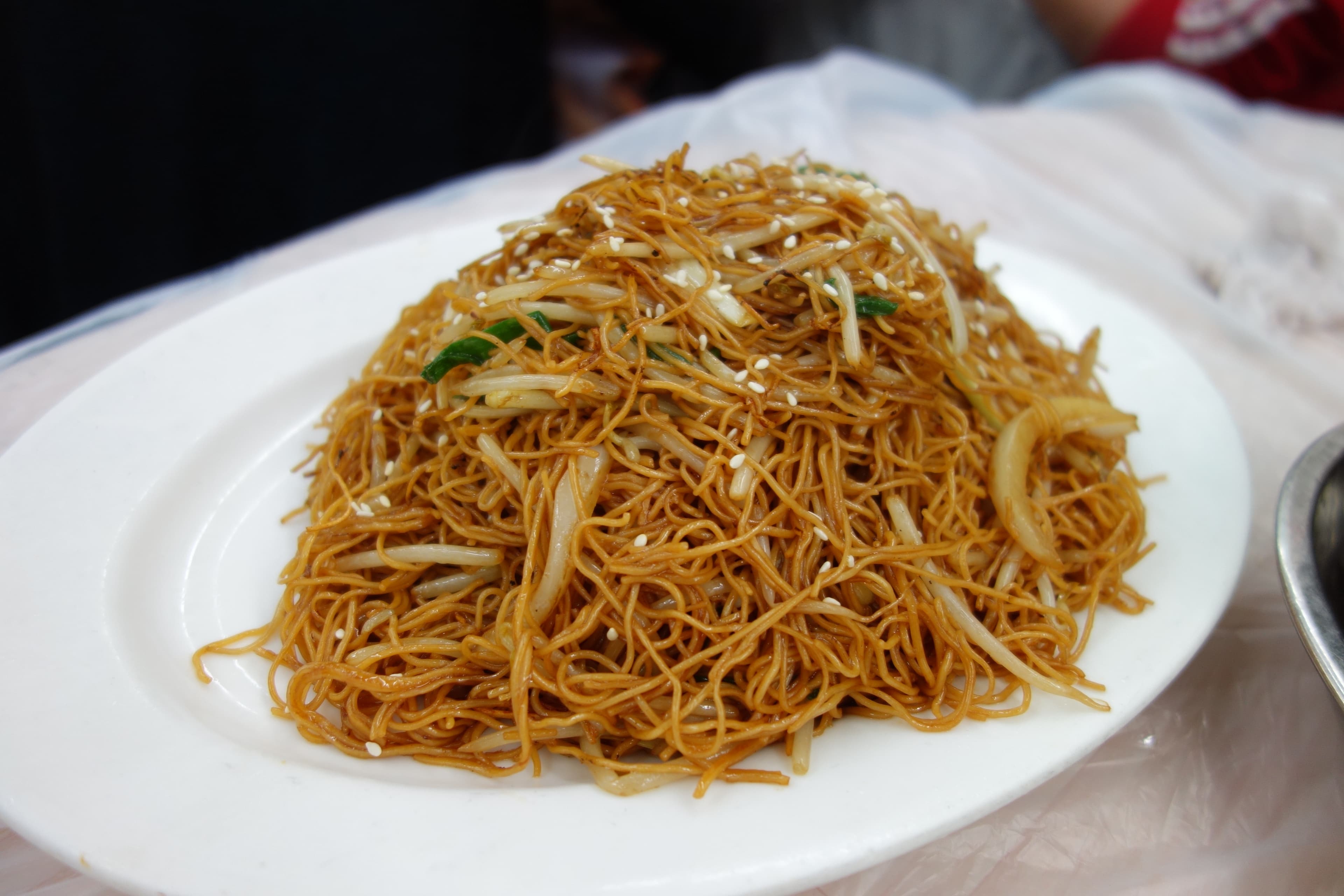 Cantonese soy sauce fried noodles with bean sprouts on a white plate
