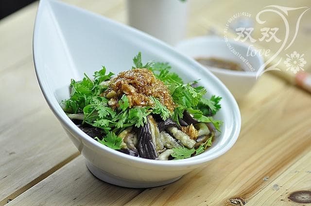 Steamed eggplant strips with garlic dressing and a coriander garnish