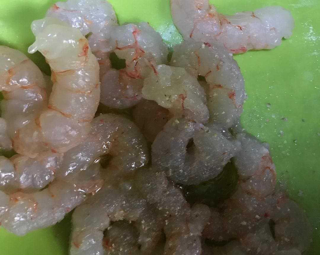 Raw shrimp lightly coated with seasoning before a short refrigerated rest.