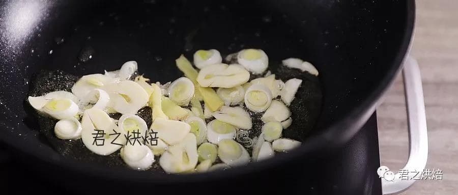 Sliced ginger, scallion and garlic sizzling in the pan.