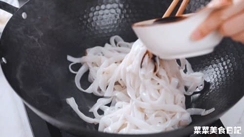 A bowl of soy-sauce mixture held over the rice noodles, ready for small additions.